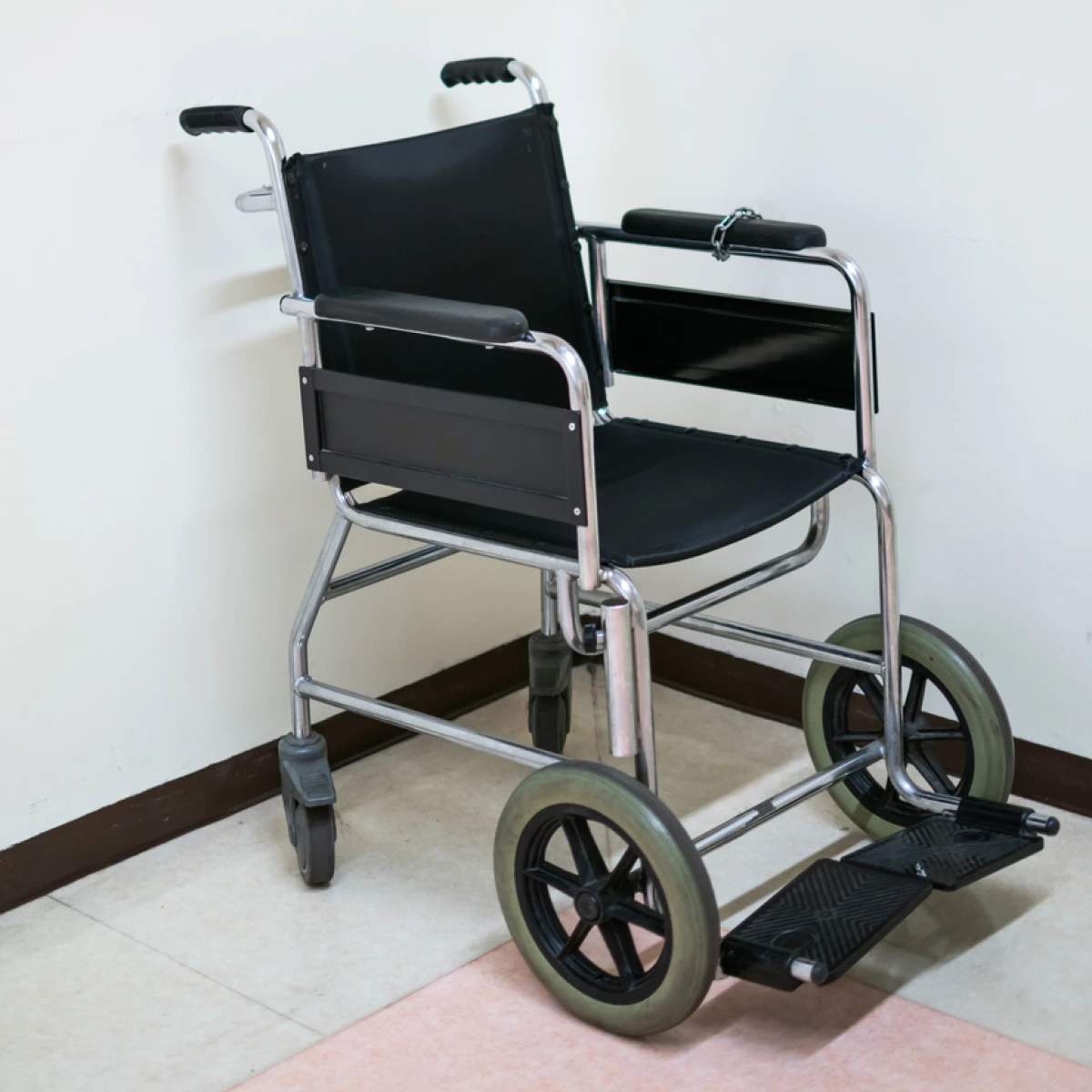 Image of Black Wheelchair on hospital floor with white background